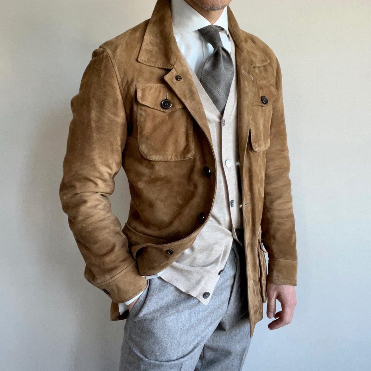 Brown suede safari jacket with large pockets worn over a waistcoat and tie.