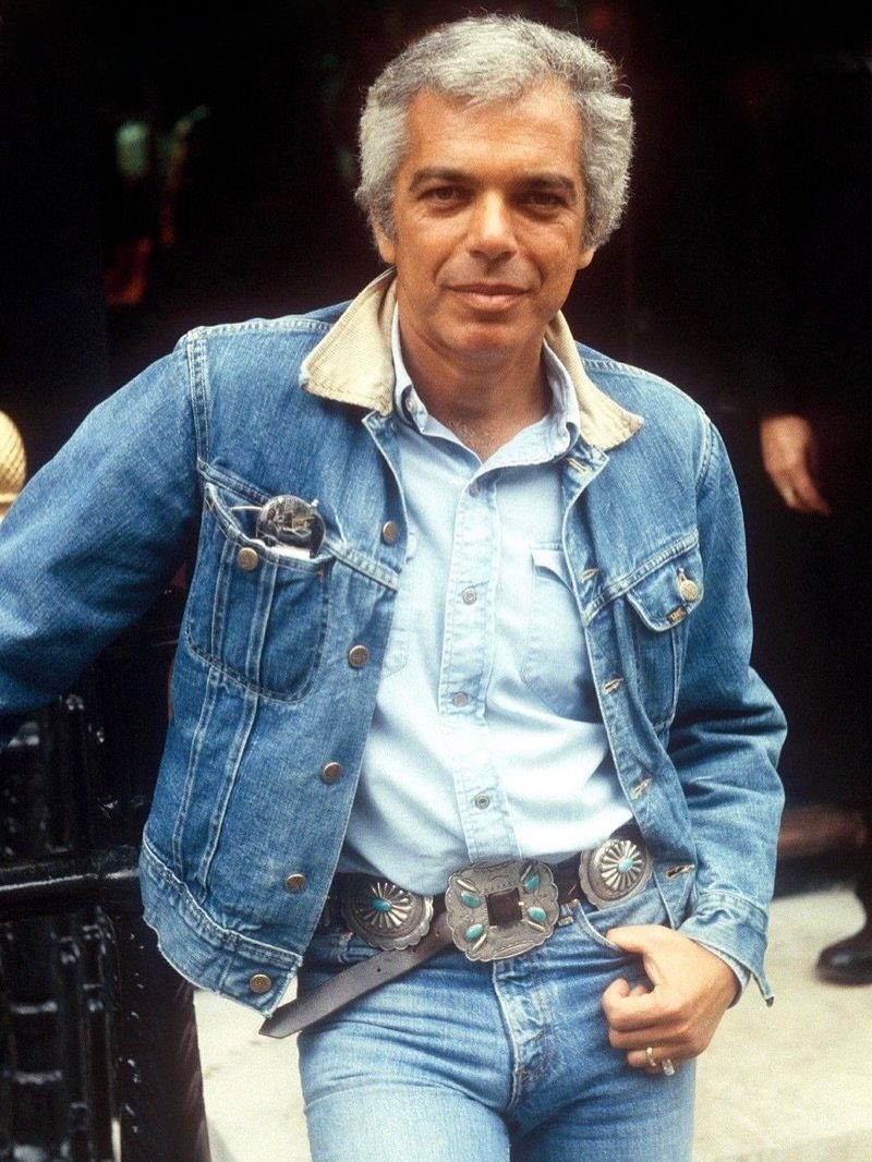 Man wearing a denim jacket, light blue shirt, and wide turquoise belt buckle.