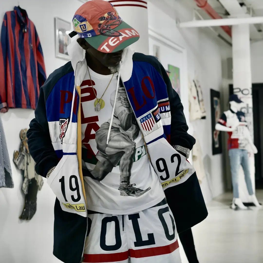 Man wearing 1990s style Polo sportswear including a color-block jacket and graphic t-shirt.