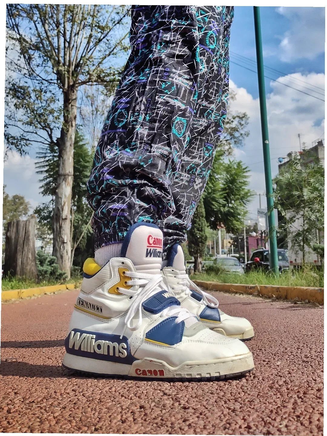 White and blue high-top sneakers with Williams branding and patterned baggy pants.