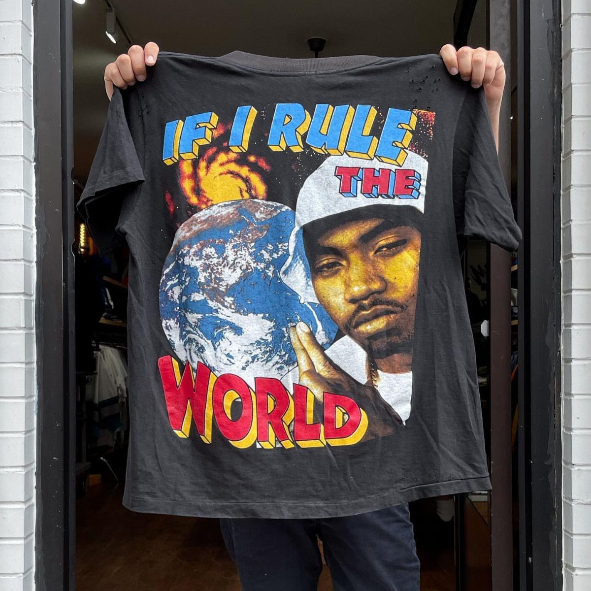 Black t-shirt with a large graphic print of a man and a globe.