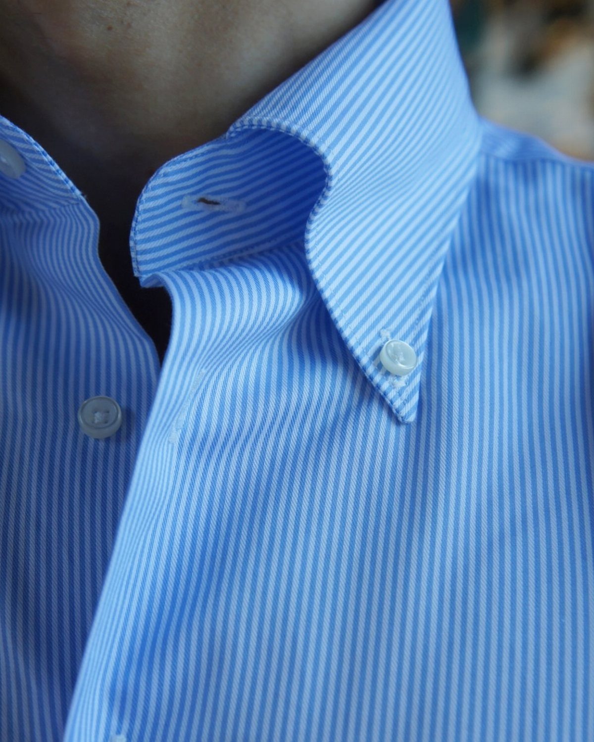 Blue and white pinstriped button-down shirt collar and chest area.