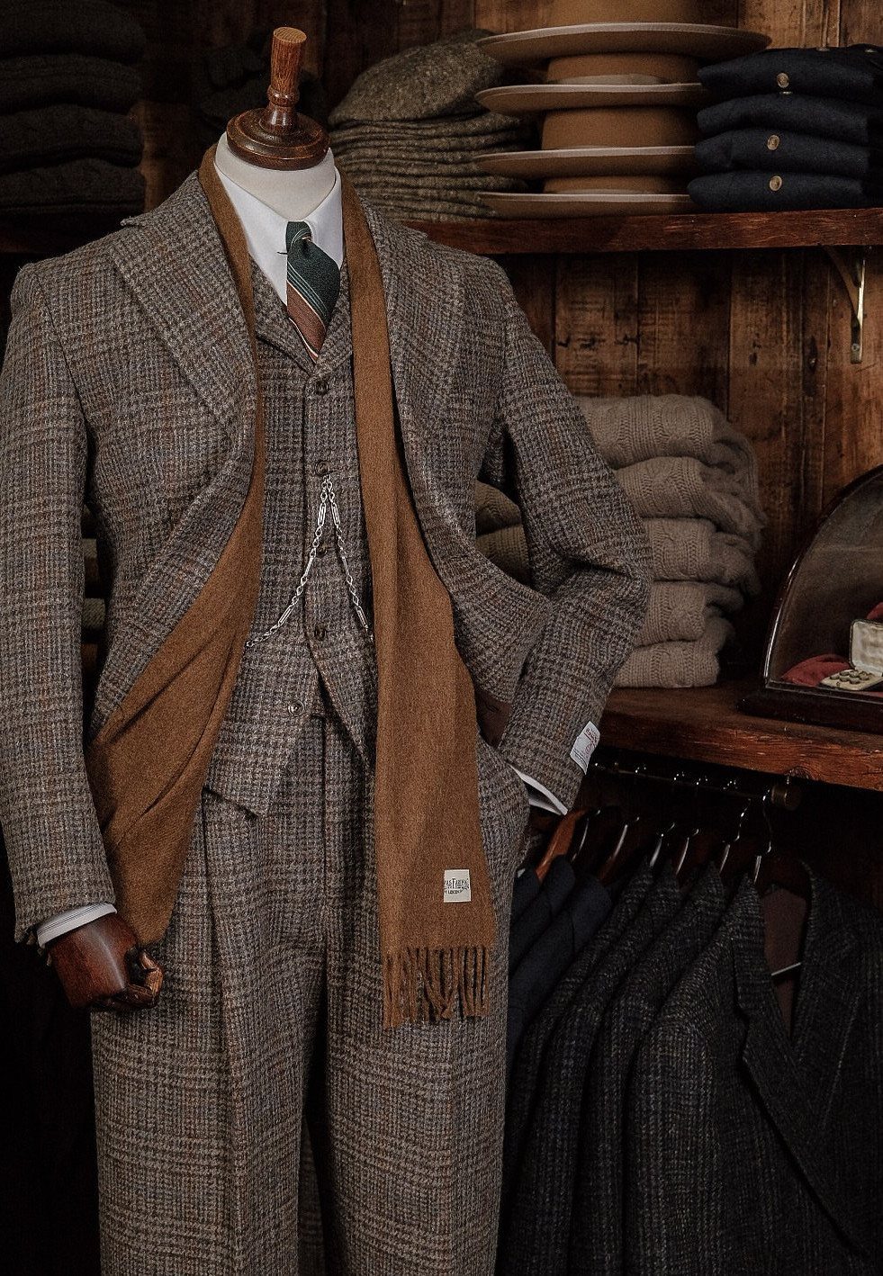 Brown tweed three-piece suit with a matching scarf on a mannequin in a shop.