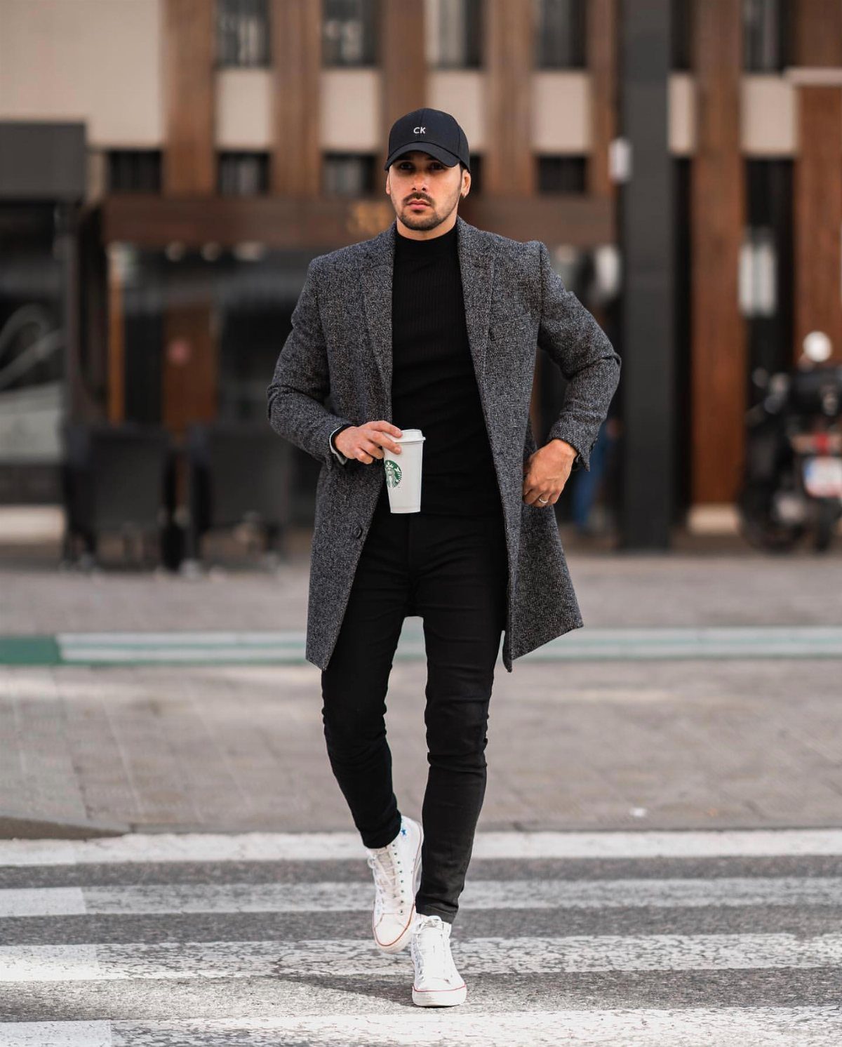 Casual Chic Dress Code Men: 16 Looks That Work in 2026 7 Man in grey blazer, black turtleneck, and baseball cap walking on city street.
