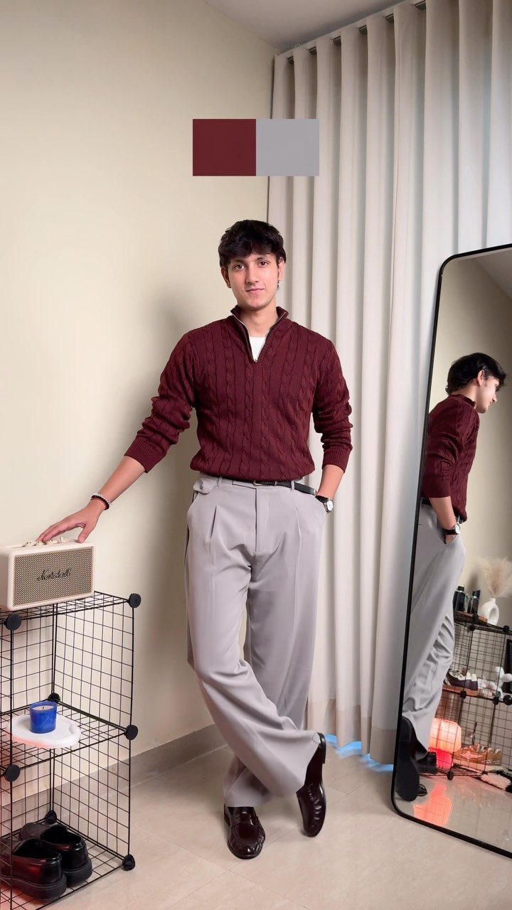 Casual Chic Dress Code Men: 16 Looks That Work in 2026 12 Man wearing a maroon quarter-zip sweater and grey pleated trousers posing in a room.