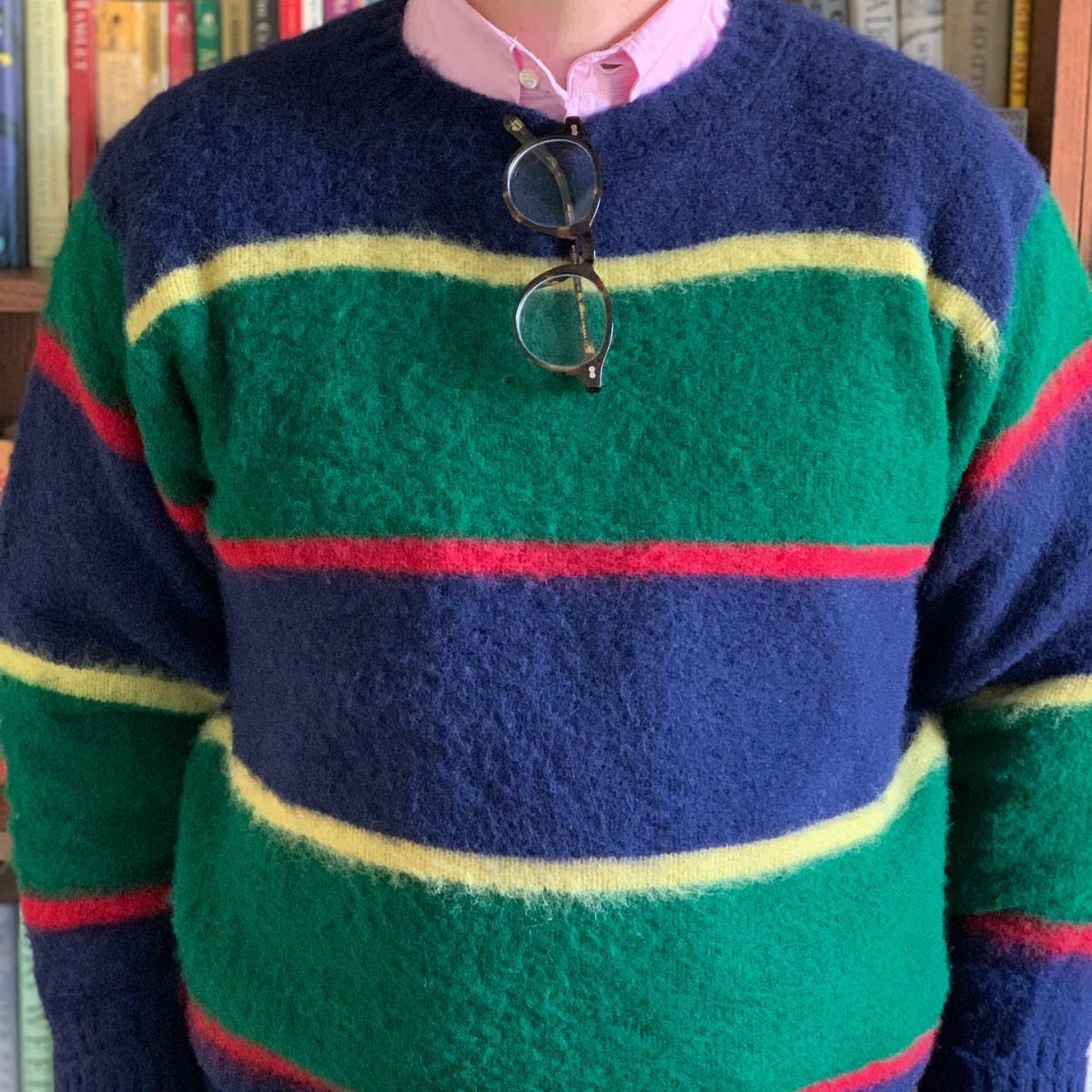 10 Images of 70's Men's Fashion from Flares to Fur Coats 4 Colorful striped fuzzy knit sweater worn over a pink collared shirt with glasses.