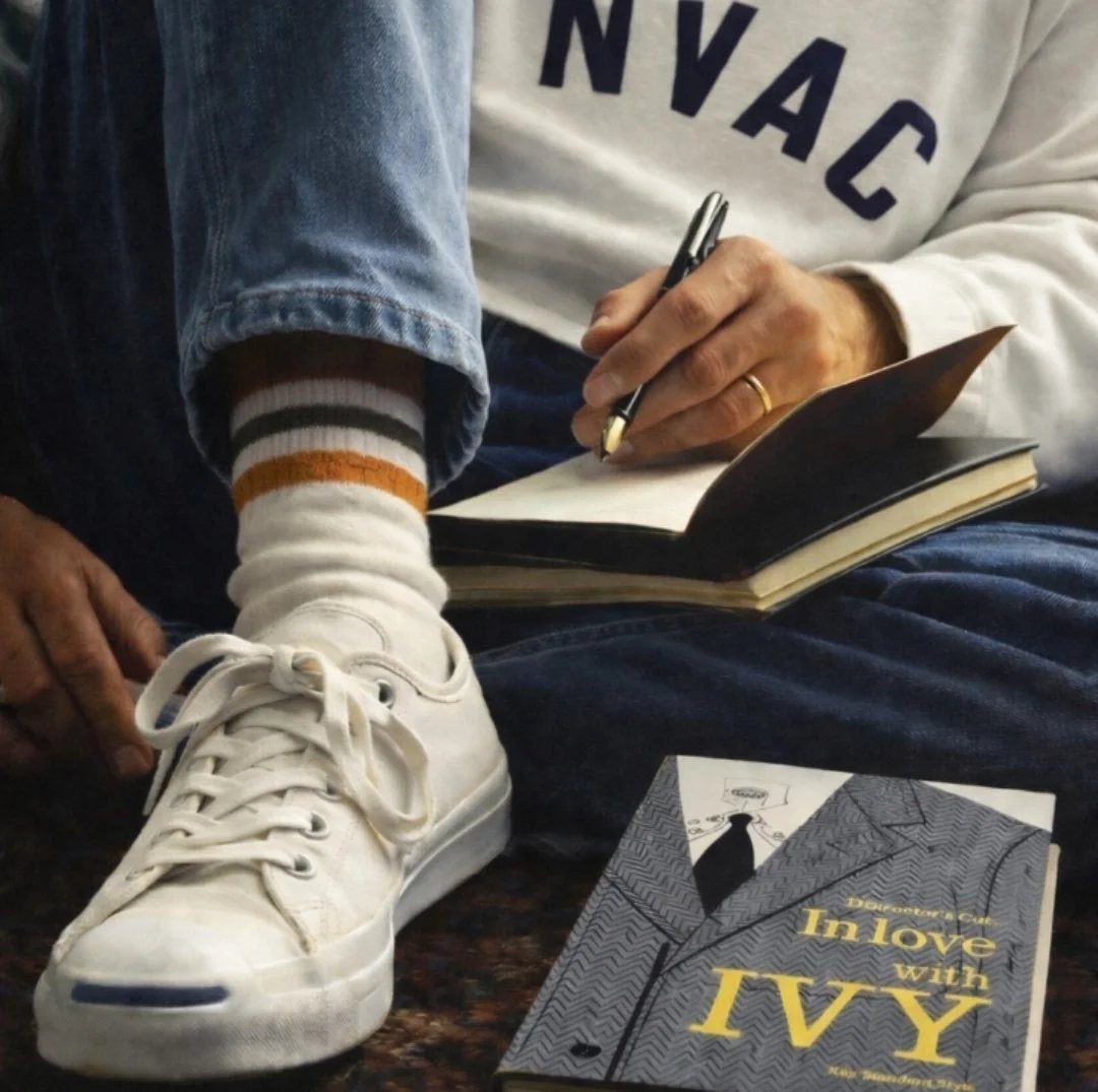 Person sitting with a notebook and a fashion book titled In Love with Ivy