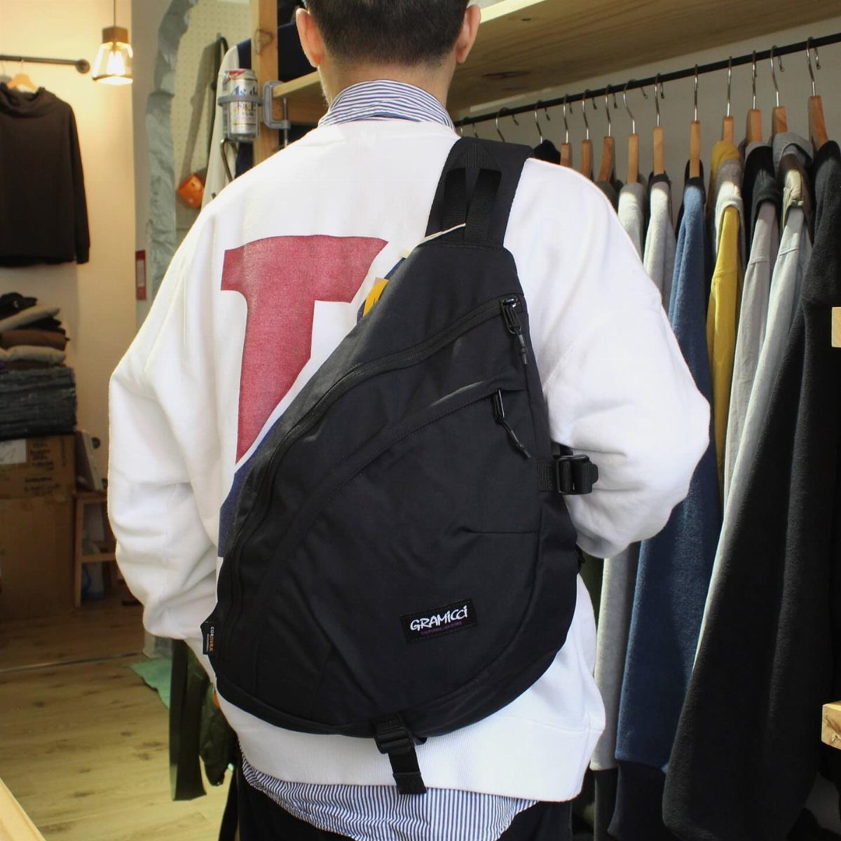 Men's Fashion Crossbody Bag: 6 Styles Worth Carrying 1 Black Gramicci cordura sling bag worn across the back of a man in a sweatshirt.
