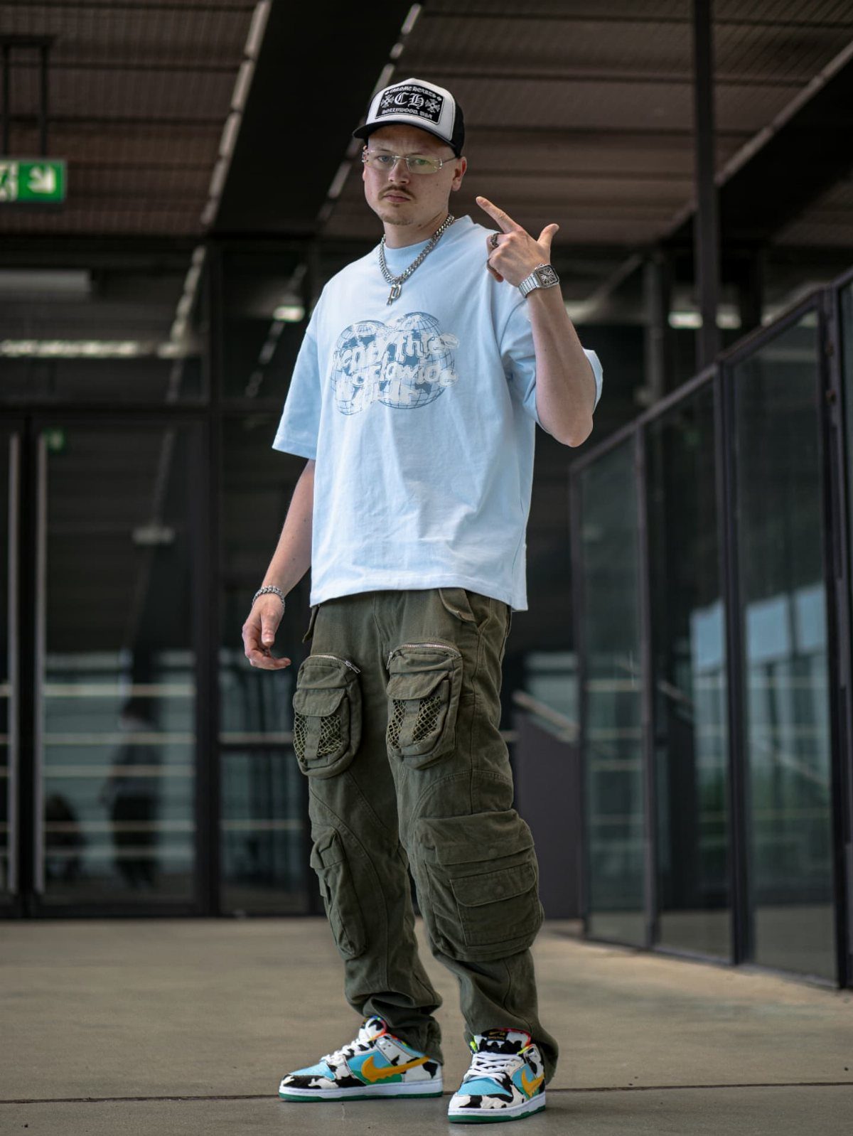 Man in cargo pants and a blue t-shirt wearing high top sneakers.