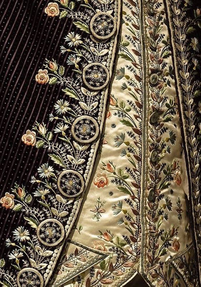 Ornate 19th-century men's coat with detailed floral embroidery and decorative metallic buttons.