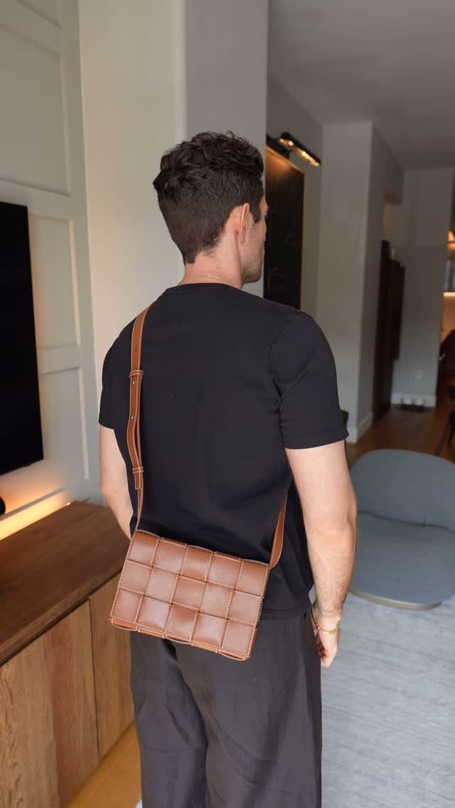 Man wearing a brown woven leather boxy crossbody bag over a black t-shirt