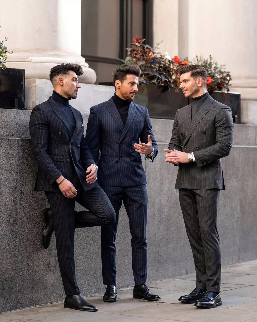 Three men in pinstripe suits and turtlenecks, featuring a navy double-breasted suit jacket.