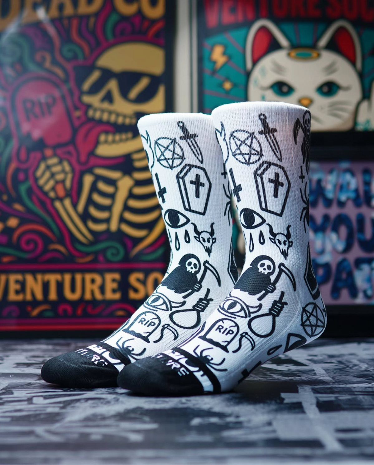 White crew socks with black gothic illustrations of skulls and coffins.