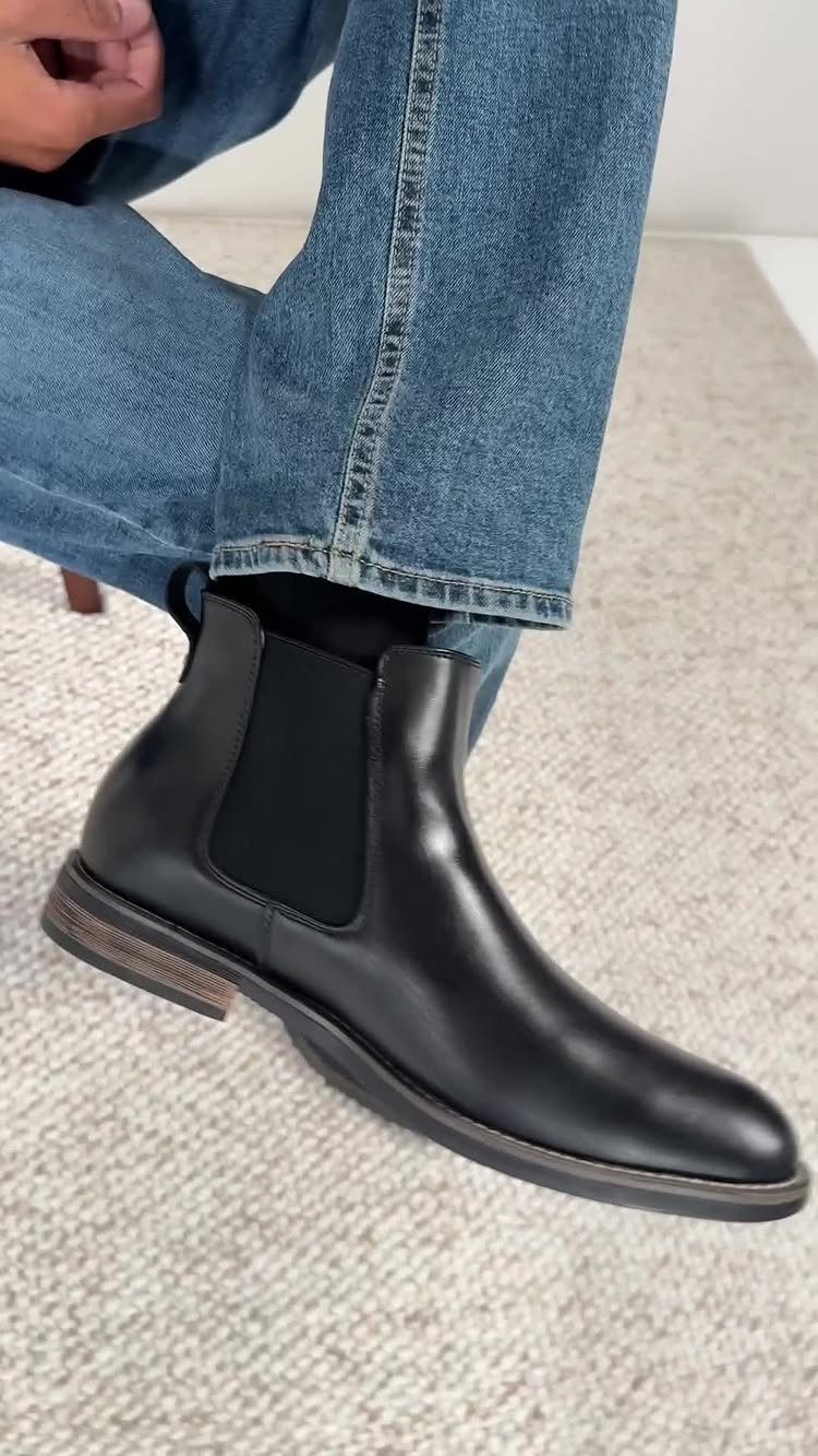 Black leather Chelsea boot with elastic side panel worn with blue denim jeans.