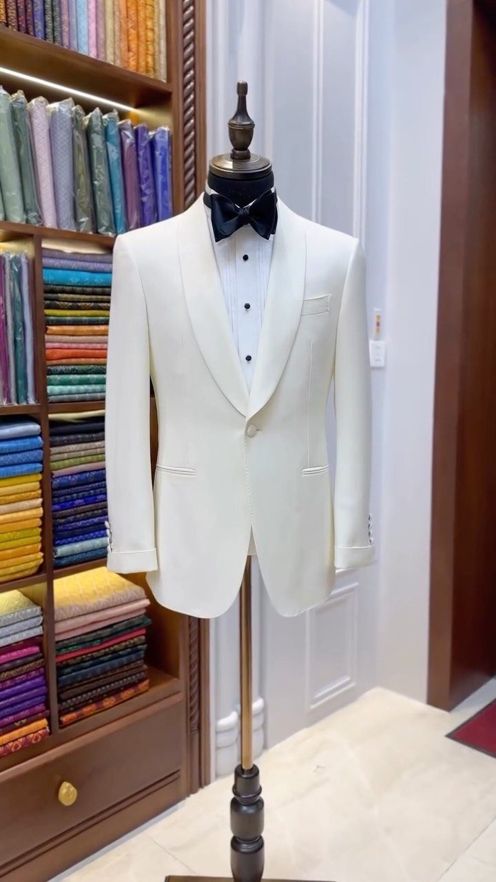 White dinner jacket with black bow tie displayed on a mannequin in tailor shop