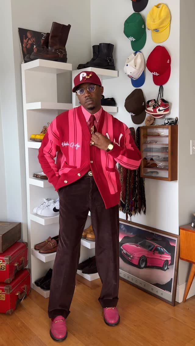 Man wearing a red striped cardigan, red shirt, brown trousers, and pink shoes.