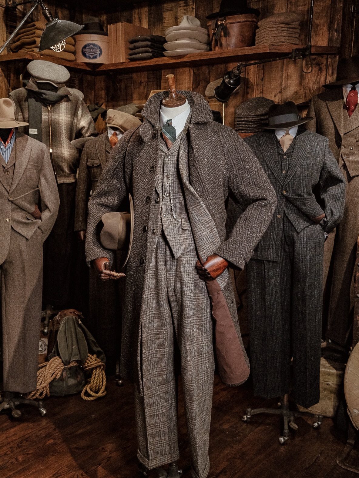 Grey tweed overcoat and matching suit on a mannequin in a vintage shop