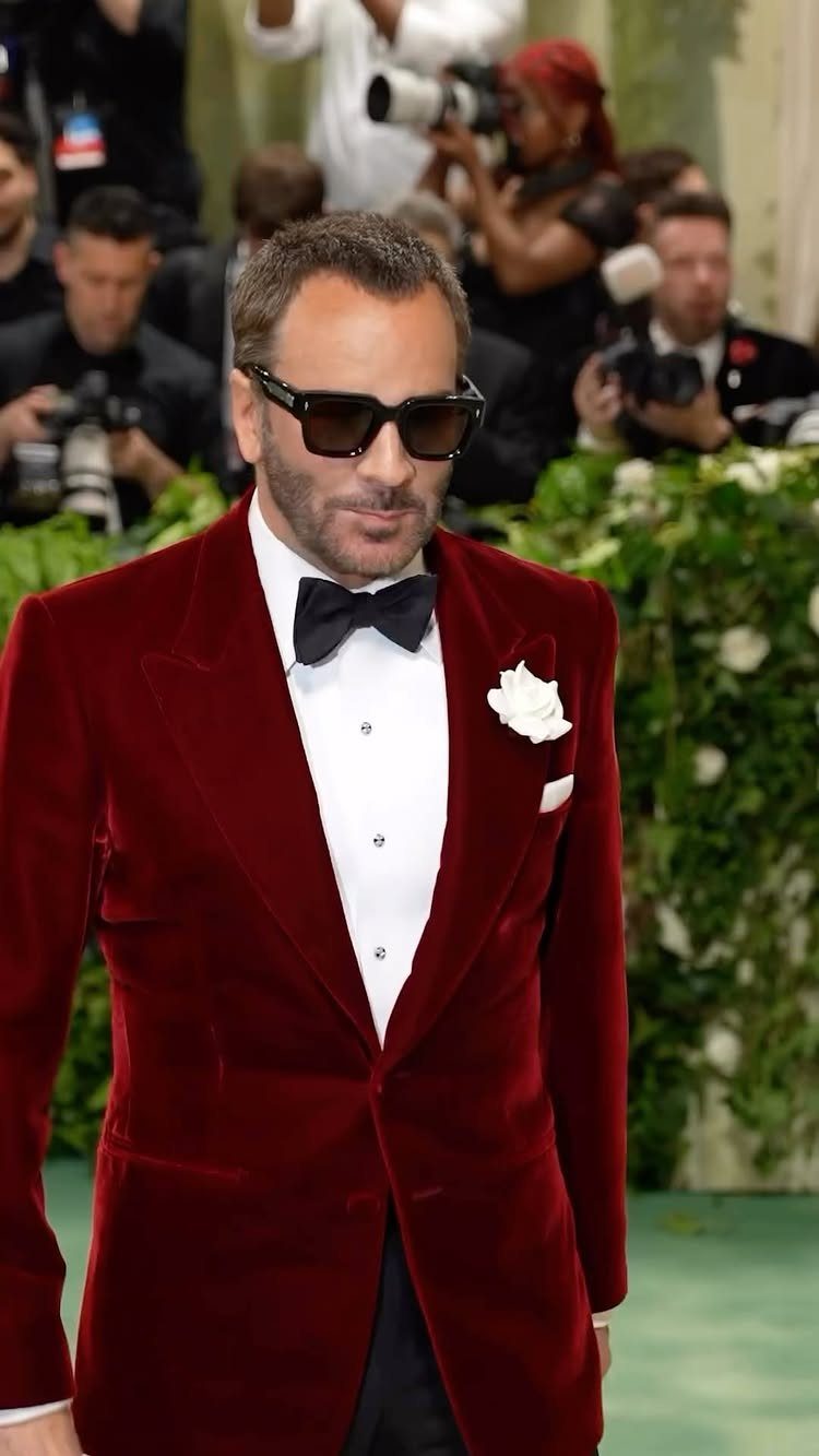 Tom Ford wearing a red velvet tuxedo and sunglasses at the Met Gala.