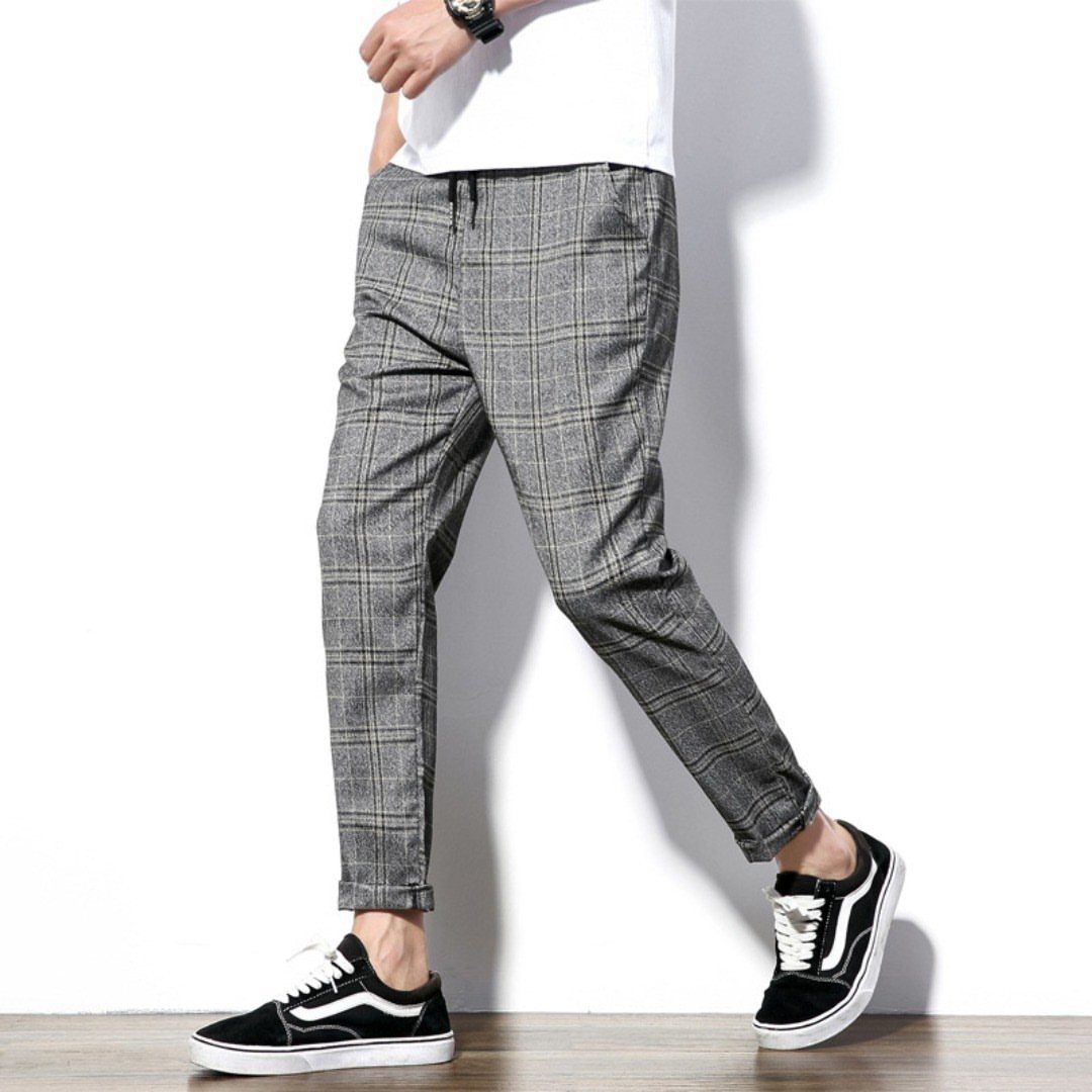 New Men's Fashion Pants: 12 Styles to Refresh Your Wardrobe 11 Grey plaid men's fashion pants paired with a white t-shirt and black sneakers.