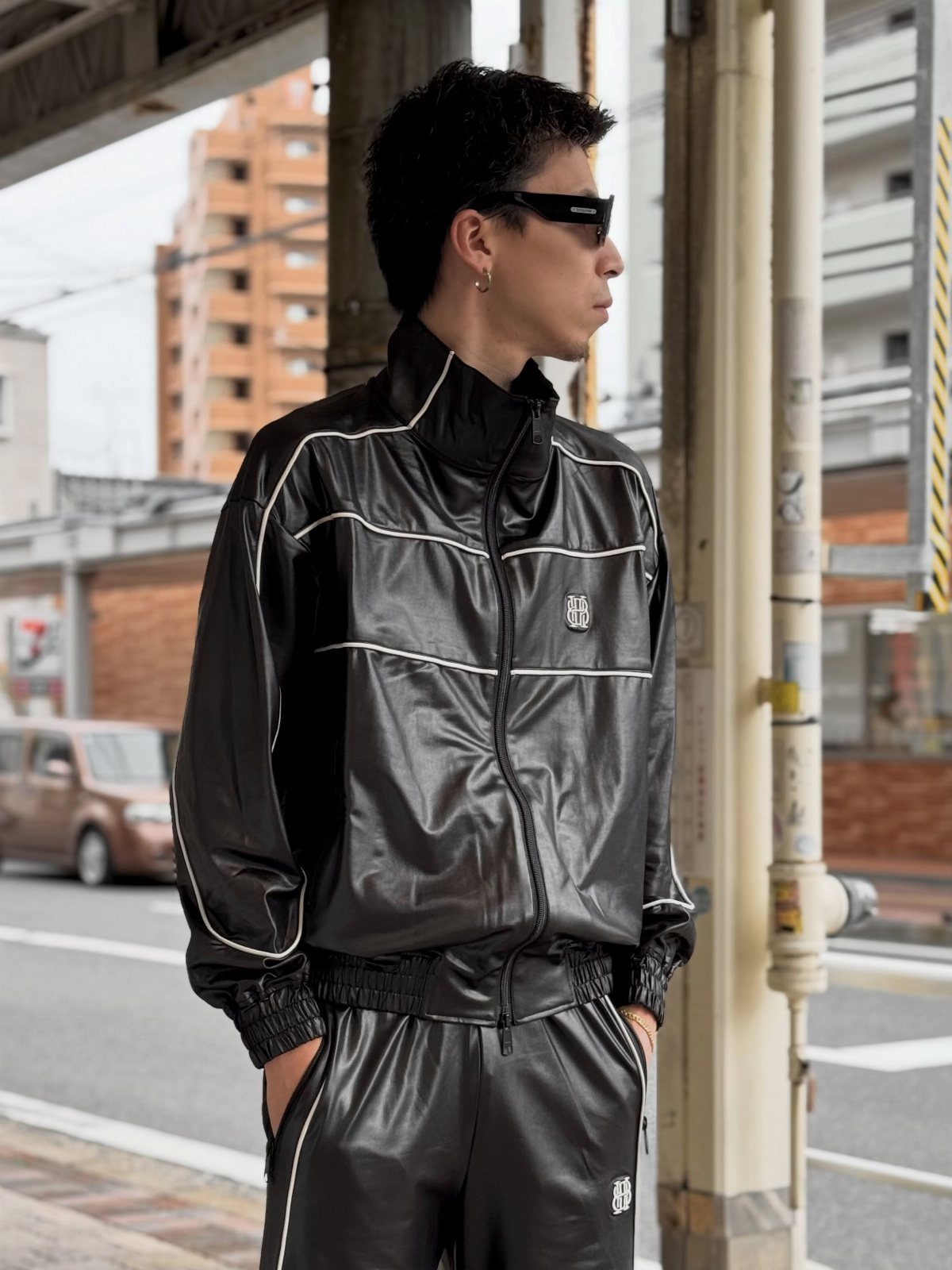 New Men's Fashion Pants: 12 Styles to Refresh Your Wardrobe 7 Man in black shiny track suit with white piping on a city street