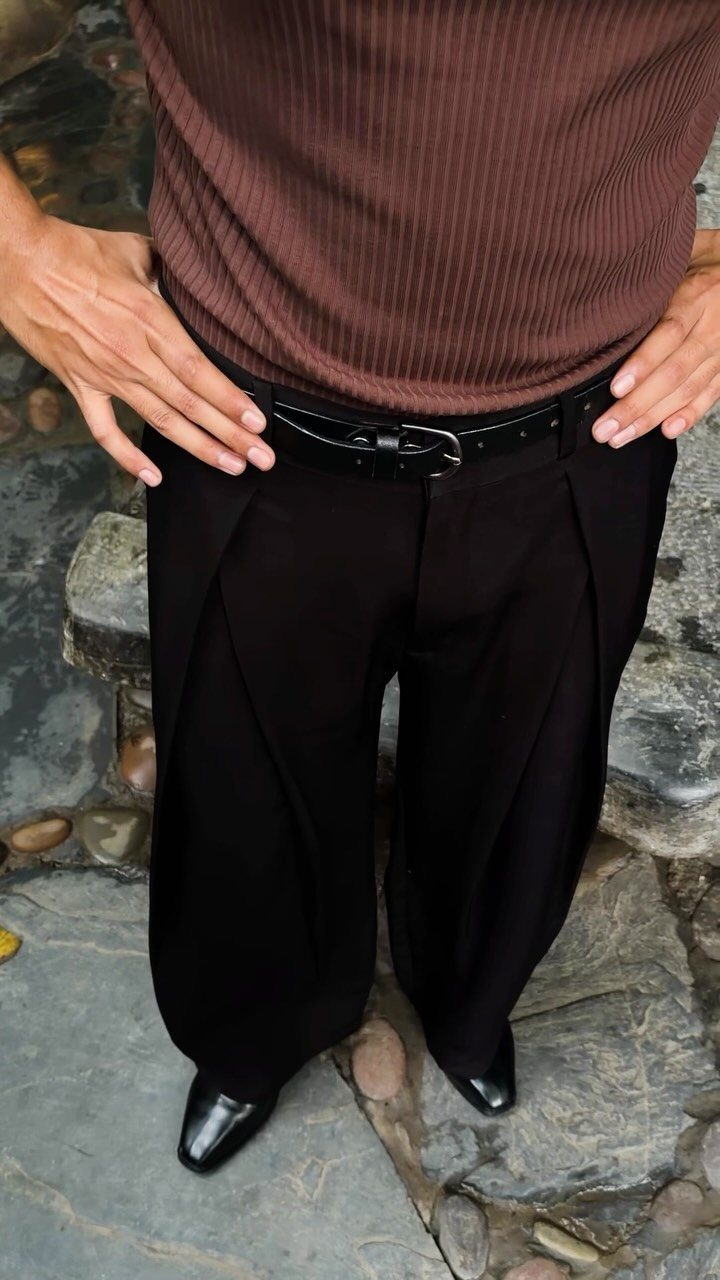 New Men's Fashion Pants: 12 Styles to Refresh Your Wardrobe 4 Black pleated trousers with a black belt and brown ribbed shirt on a man.