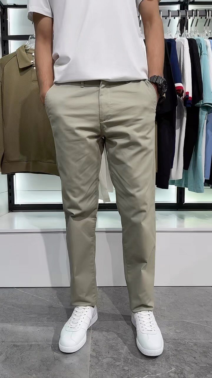New Men's Fashion Pants: 12 Styles to Refresh Your Wardrobe 10 Man wearing light beige slim-fit fashion pants and white sneakers in a store