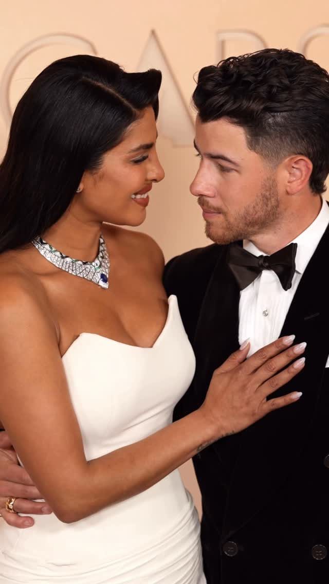 Man in a classic black tuxedo and woman in a white strapless gown posing.