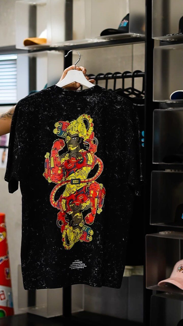 Black t-shirt with a bold red and yellow graphic design hanging on a hanger.